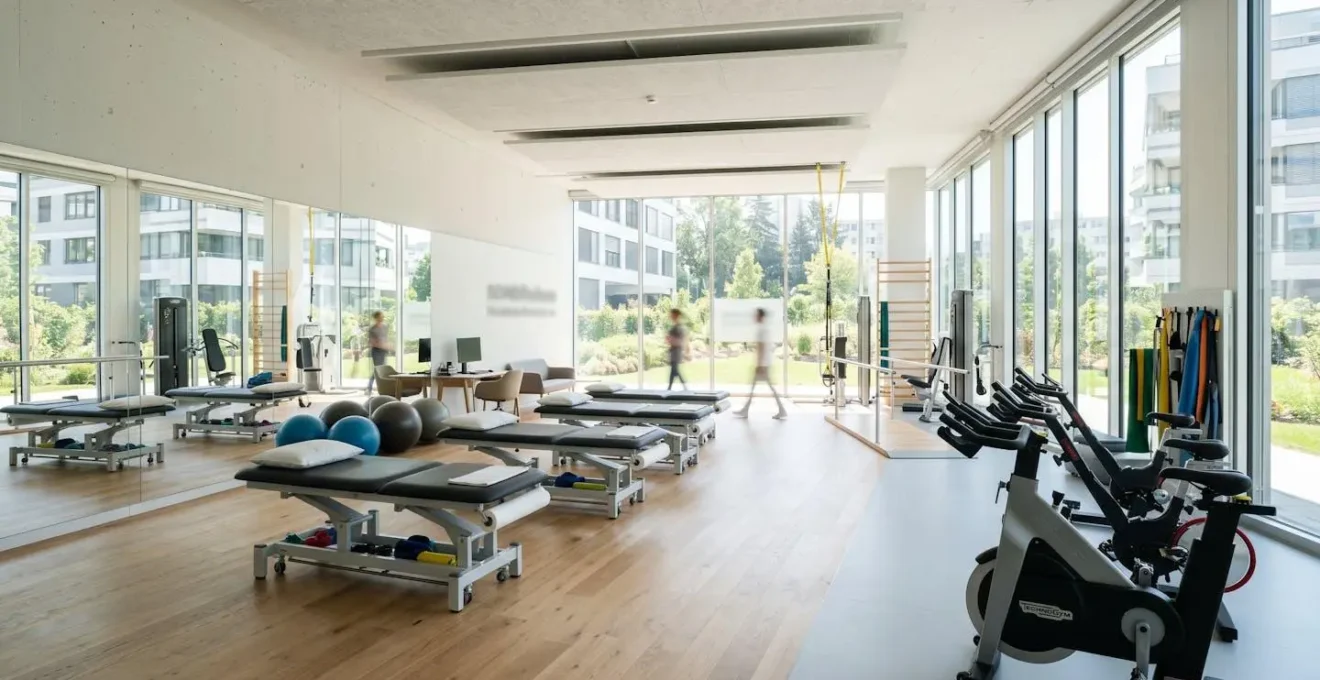Grande salle de rééducation lumineuse et moderne avec équipements de kinésithérapie contemporains, vélos et miroirs, vide